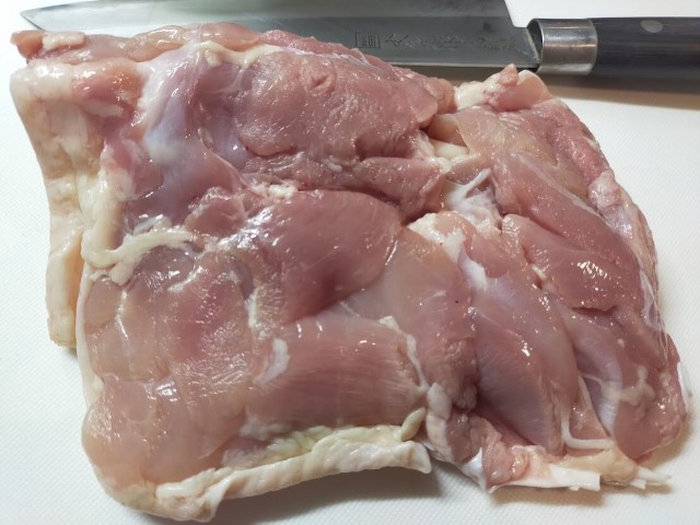皮目を下にした鶏もも肉がまな板に置かれている